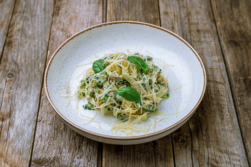 pasta fettuccine with chicken and spinach on old wooden table