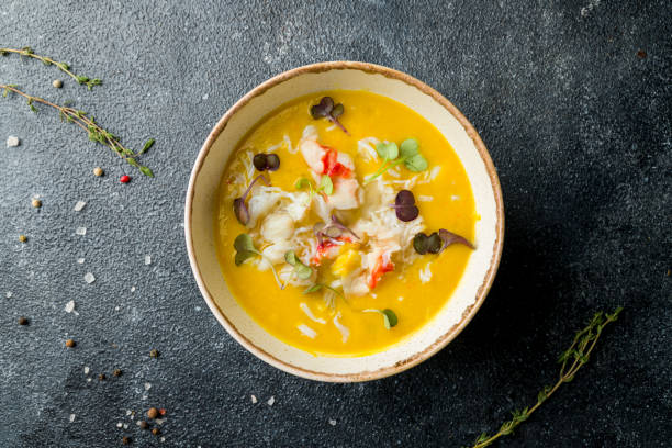 pumpkin cream soup with crab on the bowl on dark table top view