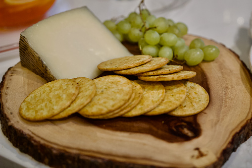 Charcuterie Board background with cheese, grapes, crackers on wooden board