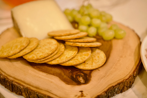 Charcuterie Board background with cheese, grapes, crackers on wooden board