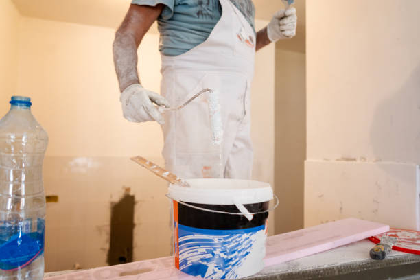 istock Senior man preparing for renovation, mixing white paint with paint roller 1416048098