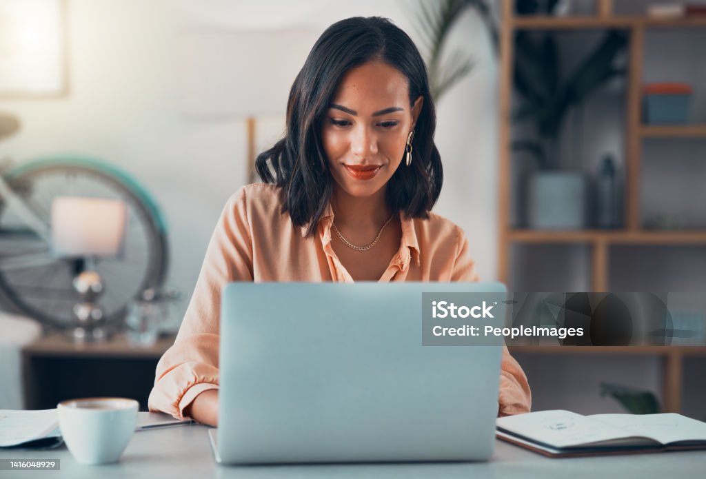 Woman working on laptop online, checking emails and planning on the internet while sitting in an office alone at work. Business woman, corporate professional or manager searching the internet People Stock Photo