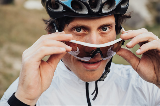 Close Up Portrait of Professional Male Cyclist, Adult Man Wearing Helmet and Protection Sport Glasses