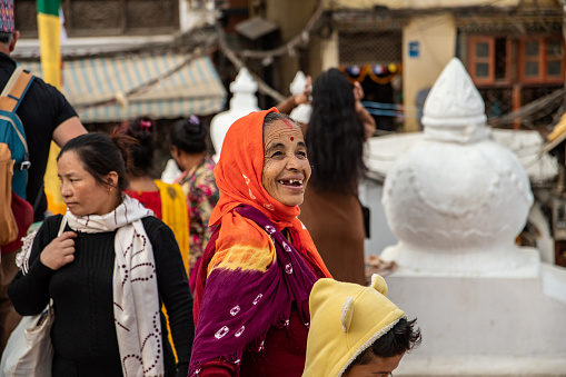 Kathmandu, Nepal - oct 30, 2019: a Tibetan woman smiles visiting the beautiful Boudhanath stupa in Kathmandu