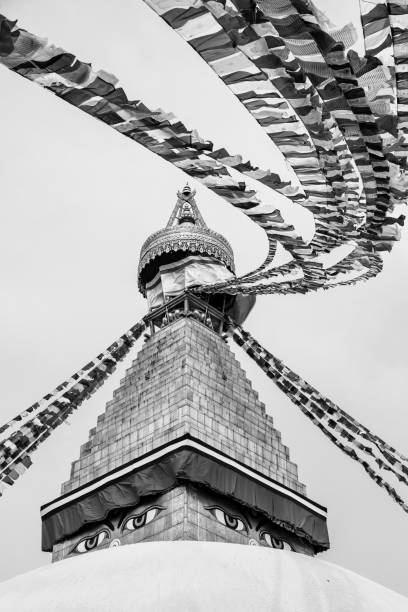 Prayers flag at Boudhanath Kathmandu, Nepal - oct 30, 2019: the spire of the Buddhist stupa Boudhanath, adorned with thousands of prayer flags, stands out in the sky of Kathmandu black and white travel travel destinations monk stock pictures, royalty-free photos & images