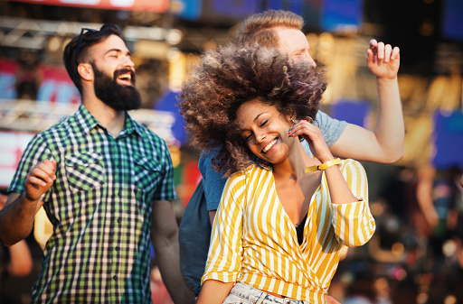 Group of young people dancing at an open air concert on a summer night.