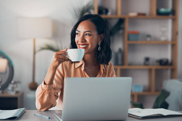 Working from home, freelancer and thinking entrepreneur drinking coffee, taking break and doing remote work while daydreaming idea. Smiling and thoughtful woman planning strategy, vision and mindset