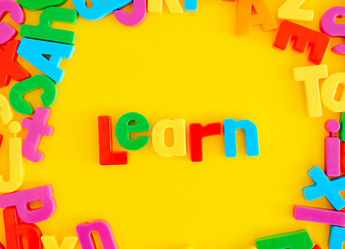 Alphabet letters backgrounds with the word LEARN on bright yellow background