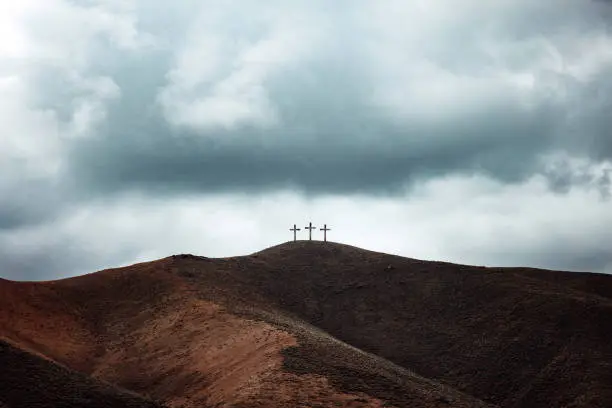 Photo of Three Crosses on Dark Hillside