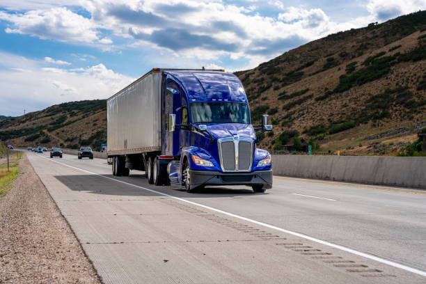 Semi Truck on a Two Lane Mountain Highway with Beautiful Clouds in the Sky Semi Truck on a Two Lane Mountain Highway shipping heavy agricultural machinery stock pictures, royalty-free photos & images