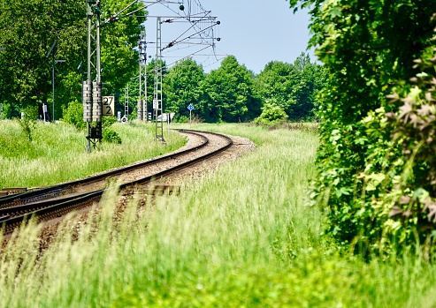 Railway tracks in summer. The turn of the railway. The railway is nearby. Grass along the railway tracks.