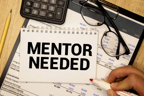 istock MENTOR NEEDED text on a sticky on a notebook with pen and glasses , blue background 1416060667