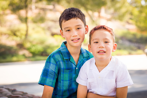 Close-up  Portrait of Two smiling boys, brothers sitting outdoor and looking at camera