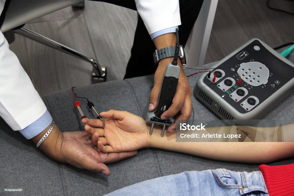 doctor's hands conducting electromyography study and nerve conduction in young woman doctor's hands conducting electromyography study and nerve conduction Human Nervous System Stock Photo