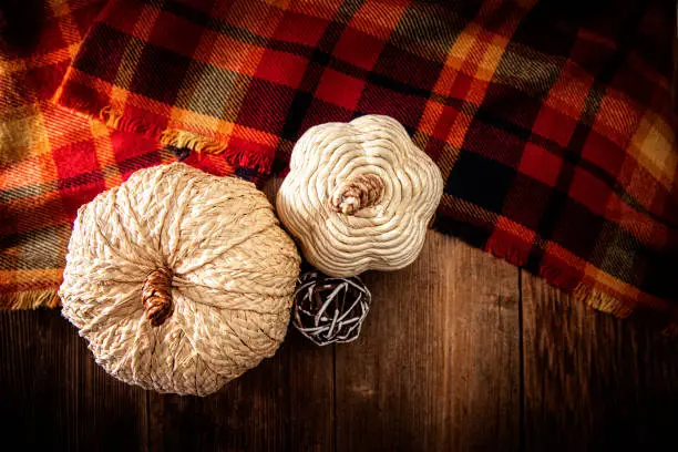 This is a close up photo of white tweed  pumpkins on a wood textured background. There is space for copy. This image would work well for autumn, fall, Thanksgiving and a holiday Halloween season in the fall.