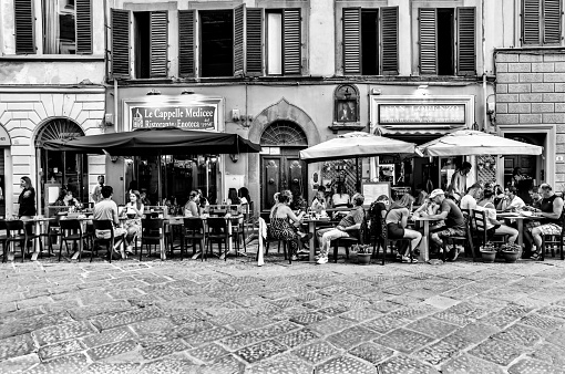 Florence, Italy - July 12, 2022: People dining on the patio of a streetside cafe in Florence, Italy