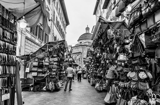 Florence, Italy - July 12, 2022: Market vendors amongst their goods in Florence, Italy