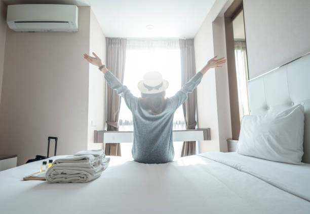 turystka podniosła rękę odpoczywając na łóżku po przyjeździe do hotelu. - bedroom hotel hotel room inn zdjęcia i obrazy z banku zdjęć