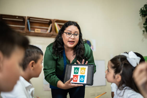 istock Teacher talking to students about recycling in the classroom at school 1416096824