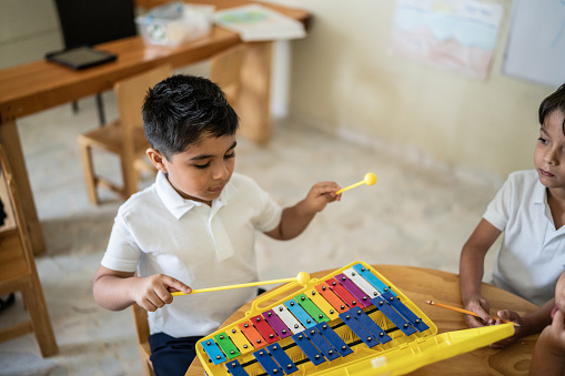 Boy playing musical instrument in the classroom