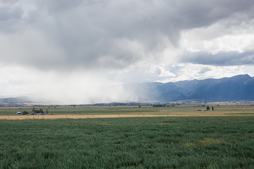 Clouds and mountains and pastures in Eastern Oregon along Interstate 84 on the road to Boise Idaho.
