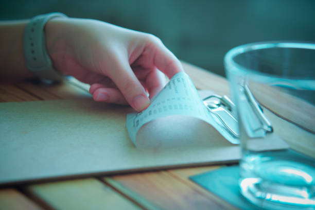 female hand, holding a bill, billing receipt.