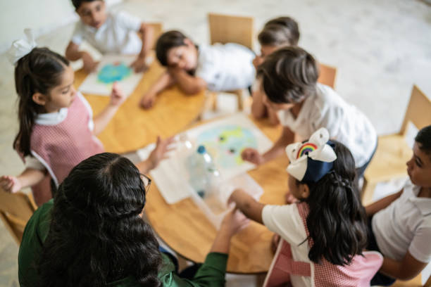 istock Teacher talking to students about recycling in the classroom at school 1416103086