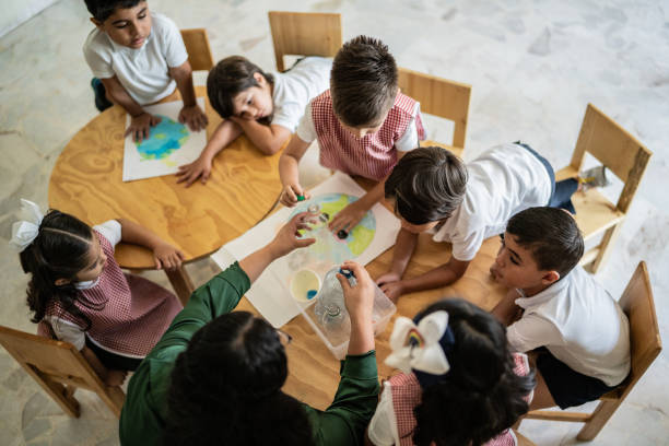 istock Teacher talking to students about recycling in the classroom at school 1416103089