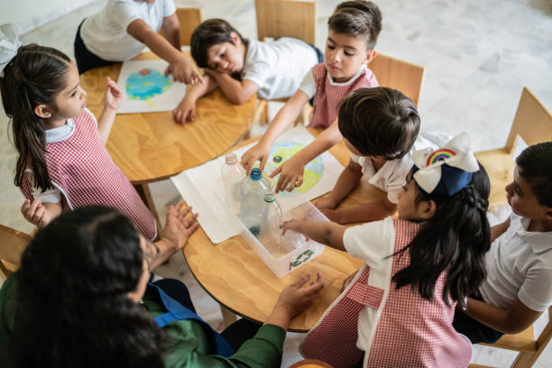 istock Teacher talking to students about recycling in the classroom at school 1416103250