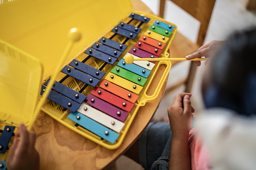 Close-up of student playing musical instrument in classroom at school