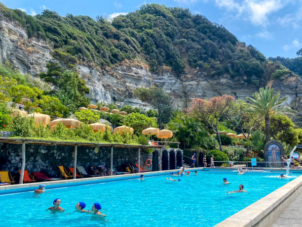 People enjoying the thermal pools and hot springs on the island of Ischia in Italy Ischia, Italy - July 23, 2022: People enjoying the thermal pools and hot springs on the island of Ischia in Italy thermal pool stock pictures, royalty-free photos & images