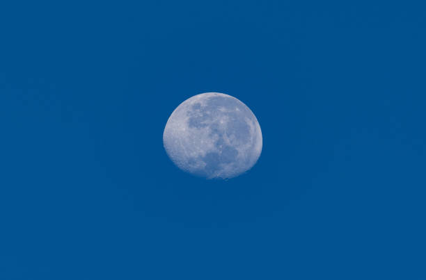 istock Full moon against blue sky background 1416152601