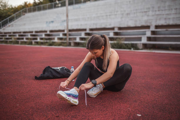 istock Young athletic woman tying shoelaces 1416153314