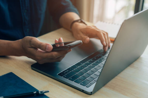 istock Businessman hand using laptop and smart phone . 1416162160