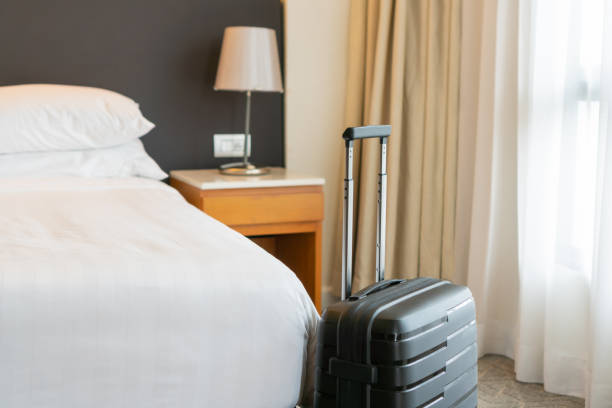 침실이나 호텔 방과 창문 커튼 배경의 검은 여행 가방. 휴일, 주말 및 여행, 출장 개념에 편안한 시간. 공간 복사 - hotel room 뉴스 사진 이미지