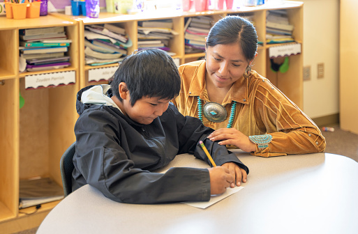 Navajo Young teacher checking one of her students progress