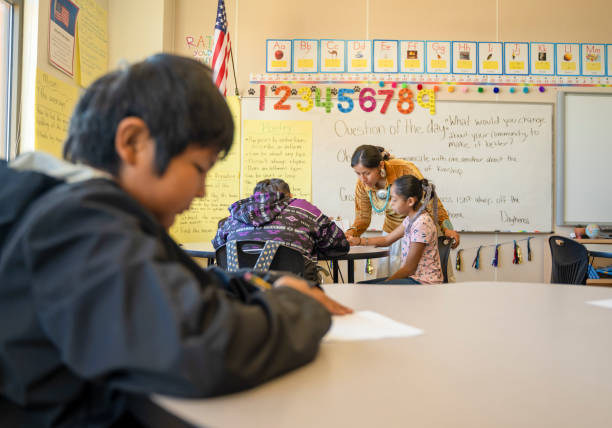 istock Indigenous navajo young teacher going around her class checking her students assigments 1416164999