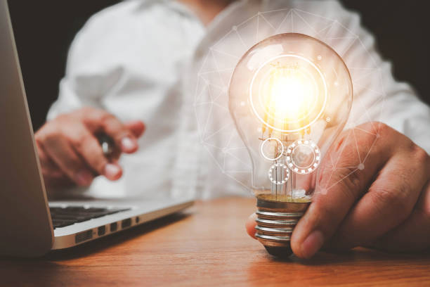 istock The hand of a man with a light bulb And there is a gear icon in it And he is using a notebook computer. idea of creativity and inspiration concept. The idea of ​​inspiration from online technology. 1416166438
