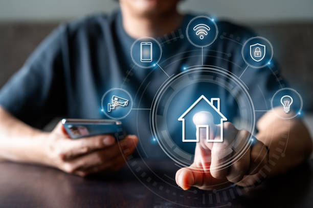 istock Man using mobile phone to control various devices in the house, Smart home technology concept 1416166453