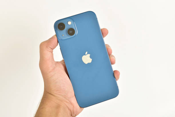 Apple iphone 13 blue in hand isolated on white background stock photo