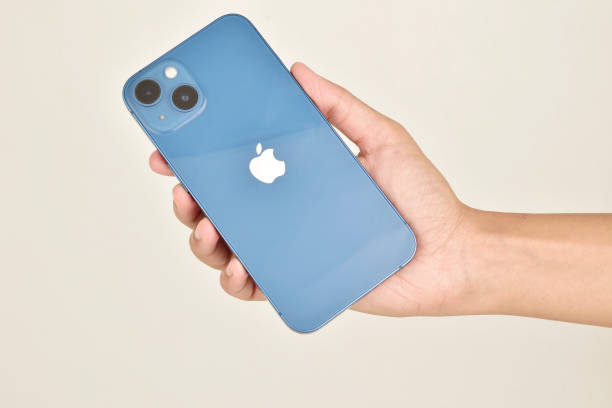 Latest blue iphone 13 in hand on white background stock photo