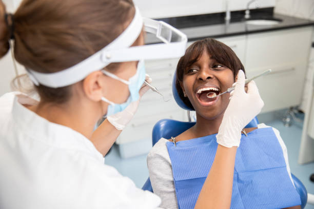 istock Female stomatologist examining teeth with dental hook and mirror 1416186127