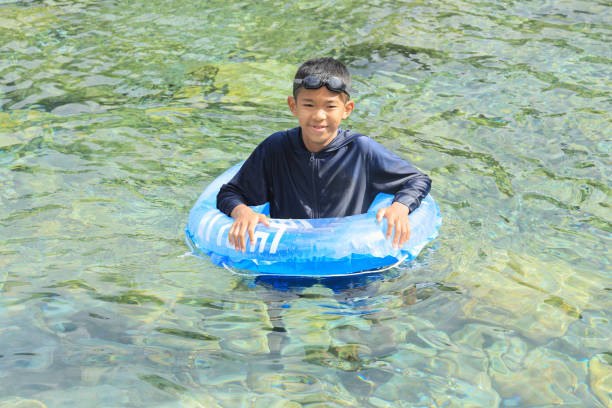 水上チューブで川で遊ぶ日本の中学生(12歳少年) - 12 13 years ストックフォトと画像