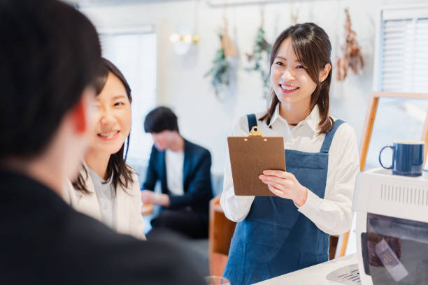 カフェで注文を受ける若手スタッフ - 店 ストックフォトと画像