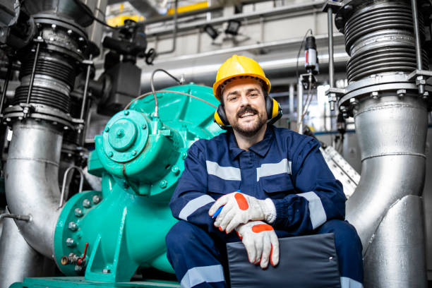 Portrait of factory worker supervisor standing by gas generator in energy heating plant. stock photo
