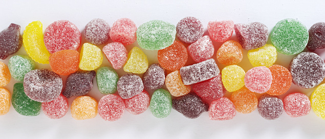 Fruit flavored pastilles mix on white background close-up, top view