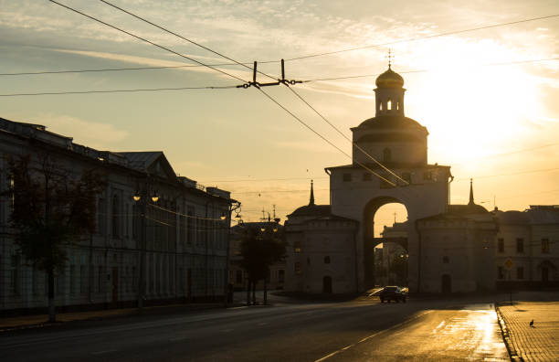 silhouette of the golden gate in Vladimir The silhouette of the golden gate in Vladimir at dawn blurred in the morning haze and the historical architecture of the city along an empty road golden gate vladimir stock pictures, royalty-free photos & images