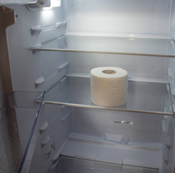 istock Empty Refrigerator. Toilet Paper in an Empty Refrigerator. White Open Refrigerator. 1416231063