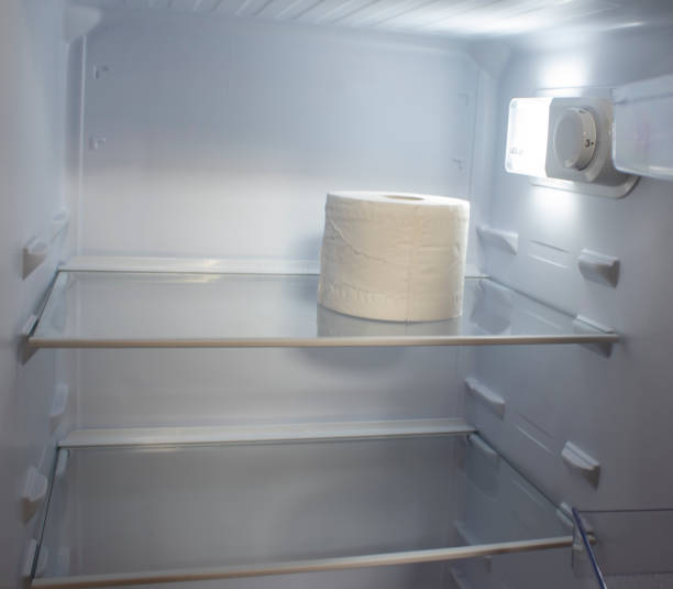 istock Empty Refrigerator. Toilet Paper in an Empty Refrigerator. White Open Refrigerator. 1416231065
