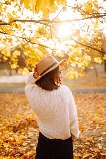 Stylish woman enjoying autumn weather in the park. Fashion, style concept.